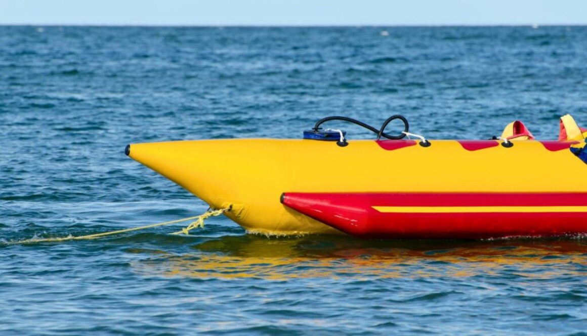 Yellow and red inflatable banana boat floating on the water, ready for thrilling banana boat rides.