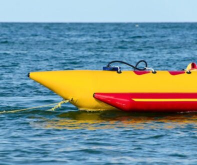 Yellow and red inflatable banana boat floating on the water, ready for thrilling banana boat rides.