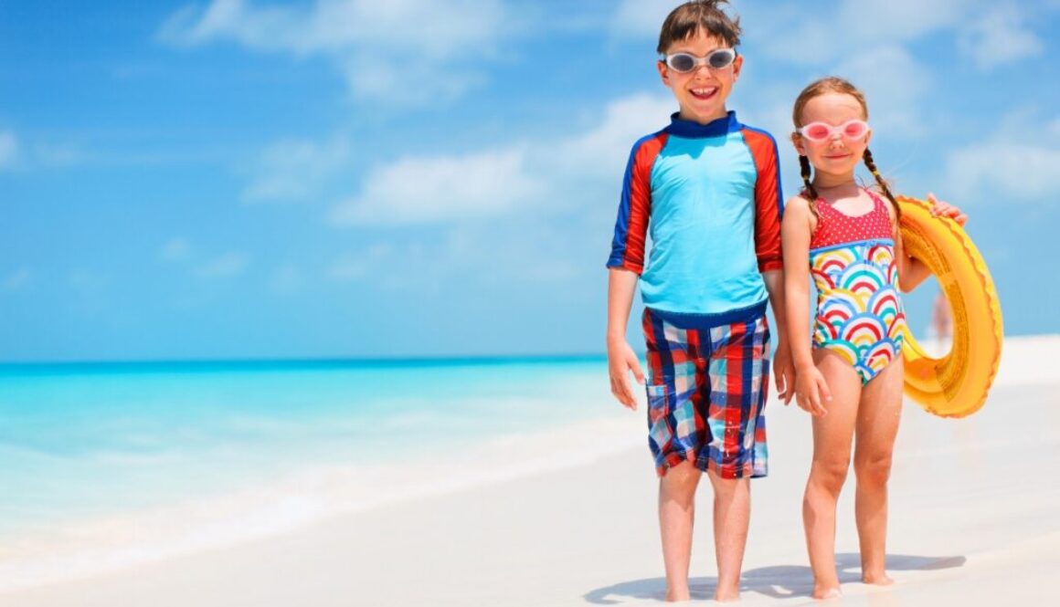 Happy boy and girl ready for beach fun, perfect for water sports for kids on a sunny day