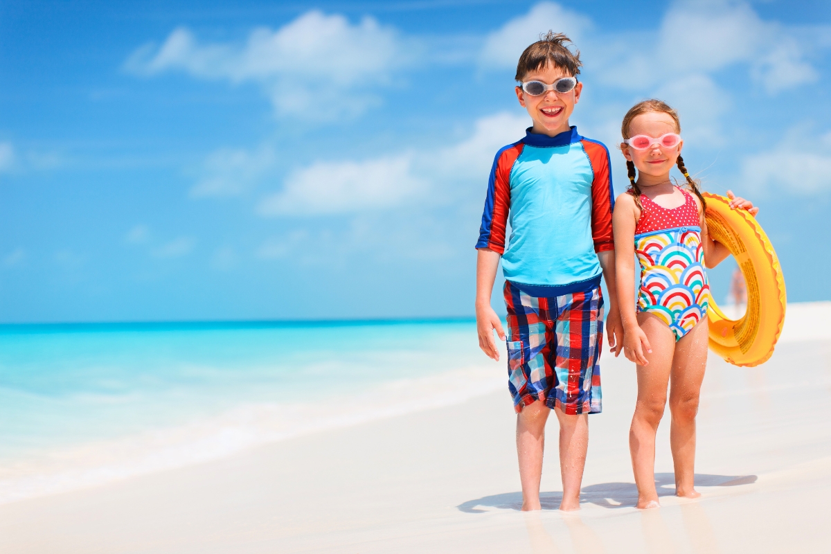 Happy boy and girl ready for beach fun, perfect for water sports for kids on a sunny day