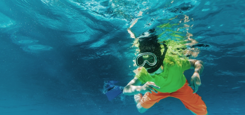 Young boy snorkeling underwater, an exciting activity in water sports for kids