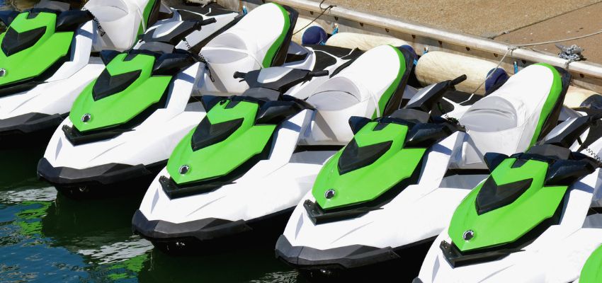 Row of personal watercraft docked and ready for use at a marina.