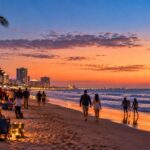 Couples and families enjoying the beach at dusk during south padre island new years eve festivities.