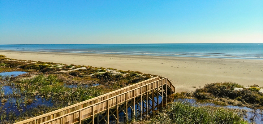 Wide sandy beach with wooden boardwalk overlooking the Gulf, answering is there a beach in texas with stunning coastal views
