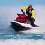 Experienced rider cutting through waves, showing advanced techniques for how to drive a jet ski.