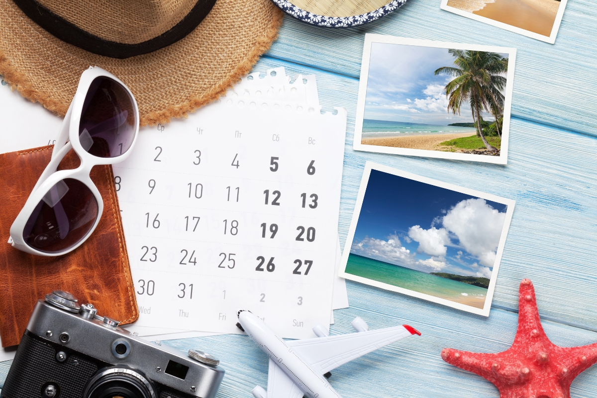 Travel planning flat lay with calendar and beach photos for choosing places to visit this summer.