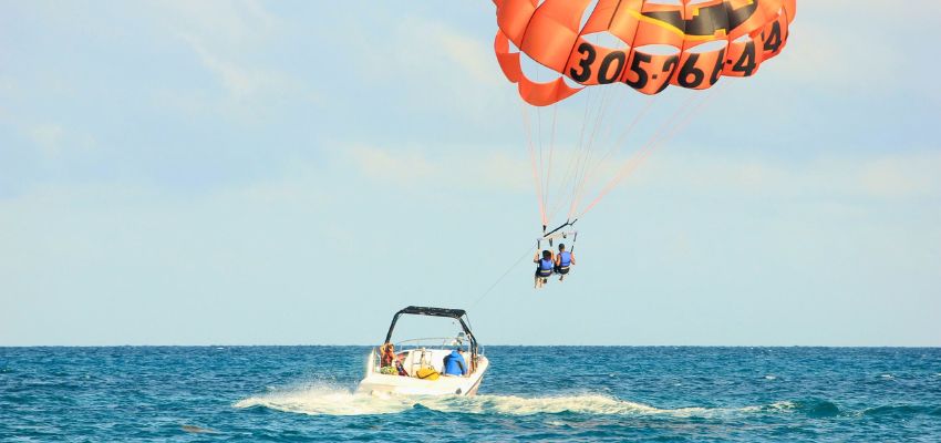 Two riders soaring high above the water while many wonder is parasailing dangerous.
