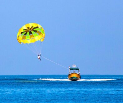 Parasailer gliding over open ocean, a scene that often raises the question is parasailing dangerous.