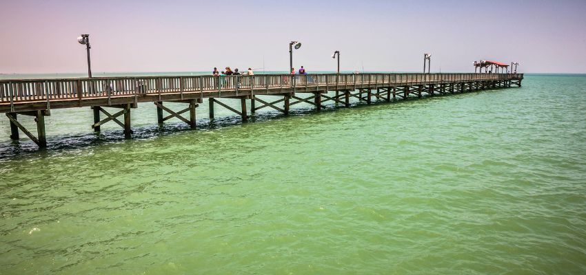 Long wooden pier stretching over turquoise water, perfect for things to do in Port Isabel.