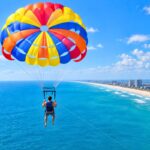 Parasailer soaring high above the ocean, showing how high is parasailing in practice.